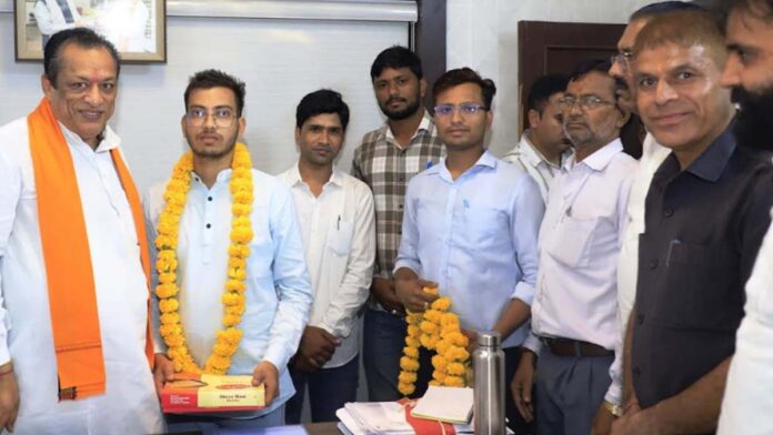 The minister honored the topper of the competitive exam