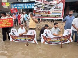 तीन फीट पानी में धरना: सड़क पर चलाई सांकेतिक नाव Sit-in protest in three feet of water: Symbolic boat rowed on the road.