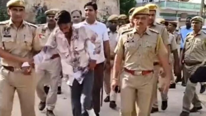 Stabbing incident in Amer: Police paraded the accused on foot through the market as he limped along. Stabbing incident in Amer: Police paraded the accused on foot through the market as he limped along.