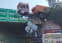 टू-व्हीलर को बचाने में डिवाइडर तोड़ पुलिया पर लटका ट्रेलर