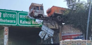 टू-व्हीलर को बचाने में डिवाइडर तोड़ पुलिया पर लटका ट्रेलर